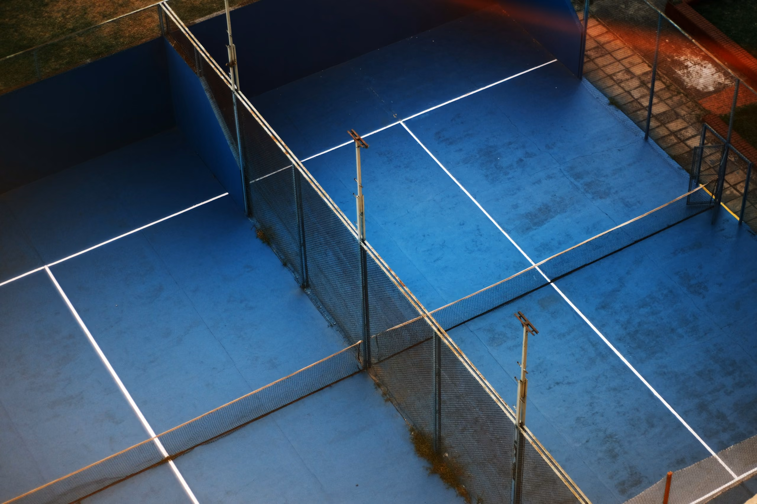 Padelbaan van bovenaf, met het glas en de belijning in beeld